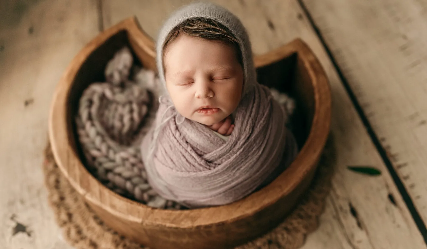 brand new baby in a heart bowl in a studio.